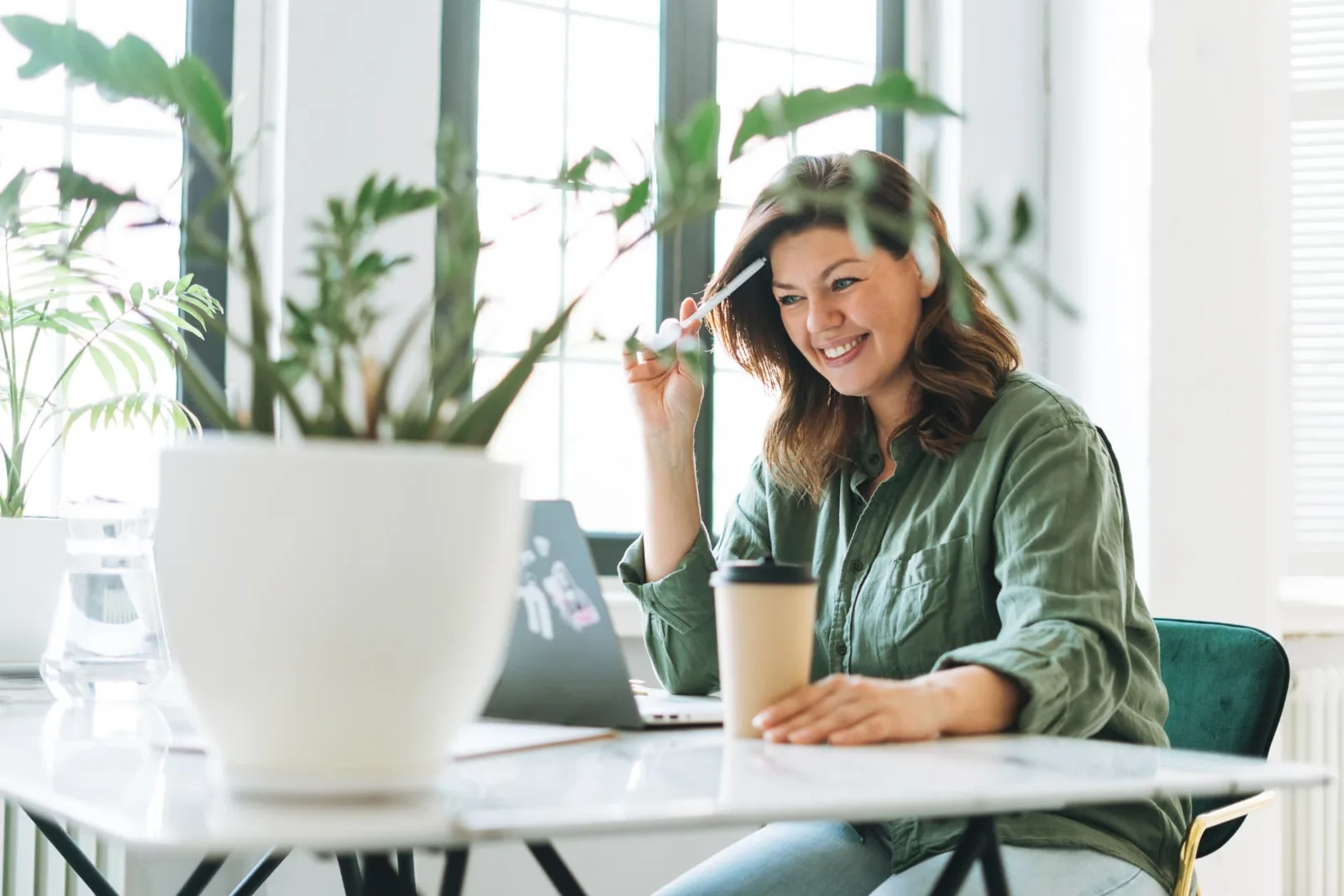 Smiling woman working at a sunlit desk